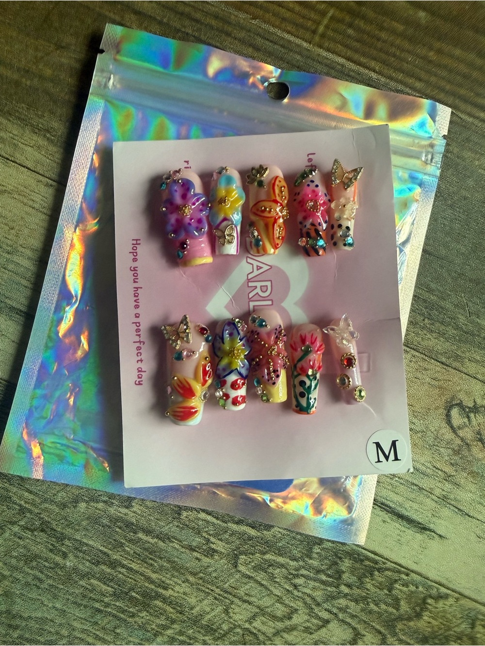 Press-On Nail Set. New, never used. Size medium. Pretty flowers and butterflies.